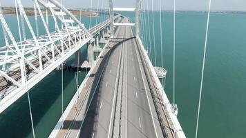 Huge bridge. Drone view. Action. A long bridge over the ocean on which cars can move freely, the bridge is located next to the green mountains video