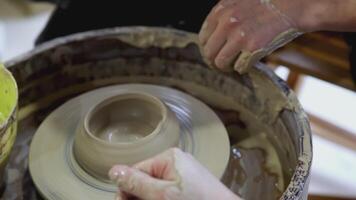 il mani di un' bambino su un' di vasaio ruota scolpire un' pentola. arte. il mani di un adulto e un' bambino nel avvicinamento siamo impegnato nel ceramica a il Festival video