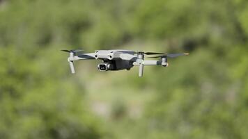 fliegend Drohne im Luft. Aktion. Drohne fliegt Über Grün Bäume. Neu Modell- von Drohne im Luft schießt Grün Bäume im Sommer- video
