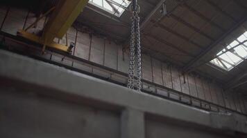 hängande krok fabrik. klämma. närbild på en metall krok. i de bakgrund, en vägg mantlad med ark av järn video