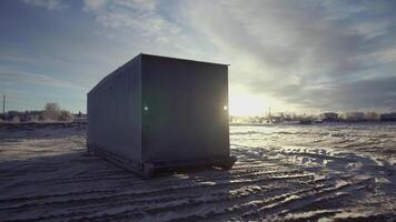 The loading container is on the snow. CLIP. View from different sides of one container standing on the ground. Blue sky and snow behind the container video