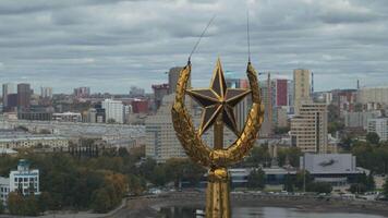 Top view of star on spire on background of city. Stock footage. Beautiful spire with star towers over city in summer. Star on spire on building in Russia video