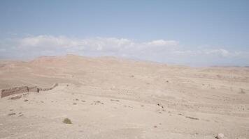Sandy desert on blue cloudy background. Action. Natural landscape with the endless desert. video