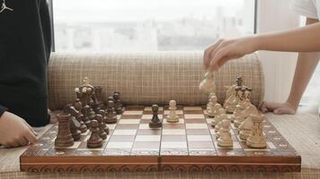 A game of chess. Creative. A chessboard with white and black pieces and two people playing. video