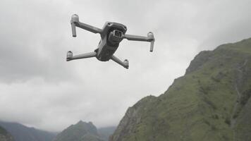 Landscape of empty mountains. Action. Mountains of gray flowers with a misty sky over which the drone flies and shoots. video