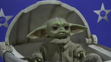 USA - - Neu York, 30.01.2022. Präsentation von Roboter Zeichen von das Star Kriege Universum. hdr. Baby yoda oder grogu Sitzung im das Wiege und ziehen um seine Kopf, Mandalorianer. video