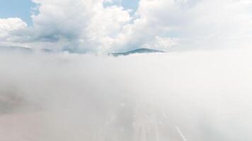 superiore Visualizza di denso nuvole nel cielo con montagna picchi. azione. volante al di sopra di bianca nuvole su sfondo di celeste orizzonte con montagna. panorama di nuvoloso cielo e orizzonte con montagna picco video