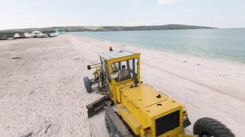 Yellow transport on the beach. Action. View of thw drone. Wonderful scenery of coast. Huge beach against the blue sky video