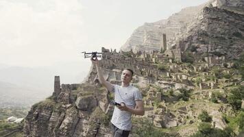 Wonderful summer landscape. Action. A view of the mountains and how a young man launches a small drone in front of the blue sky. video