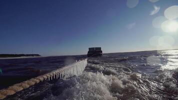 groß Lastkahn beim das Norden Pole. Clip. im das Vordergrund Seil mit Eiszapfen. im das Hintergrund, ein schwer Lastkahn im Eis Wasser ist im Fokus. ein Schiff ziehen ein Lastkahn im Abschleppen video