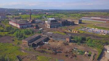 View of the work area from the drone. Clip. A large factory with pipes from which smoke is coming, the city and the forest and the calm sky are visible from behind. video