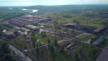 a volo d'uccello Visualizza. clip. un' piccolo cittadina con industria, piccolo case qui vicino, un' bellissimo fiume con un' ponte al di sopra di esso con macchine e in giro un' verde luminosa paesaggio e un' luminosa cielo. video