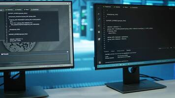 Computers in empty data center facility managing rackmounts energy consumption. Close up of script on PC monitors used for automation and monitoring processes in server room, camera A video