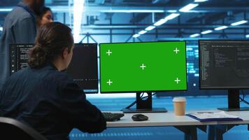 Software developer using green screen PC to do programming in server room providing computing resources for workloads. IT expert supervising data center supercomputers using mockup computer monitor video