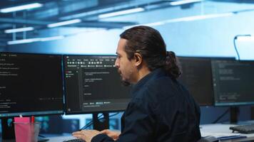 Knowledgeable engineer upgrading equipment in data center, zoom in shot. Specialist at PC desk in high tech establishment overseeing server rows, typing on keyboard, close up shot video