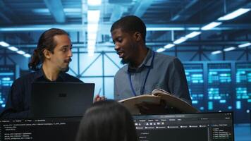 African american inspector investigating server hub, reading paperwork and evaluating parameters. Supervisor doing inspection in data center, checking reports and analyzing hardware performance video