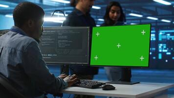 esso tecnico guardare a verde schermo pc, Lavorando nel dati centro, garantendo ottimale prestazione. uomo monitoraggio energia consumo attraverso operativo server impianti di perforazione componenti utilizzando croma chiave tenere sotto controllo video