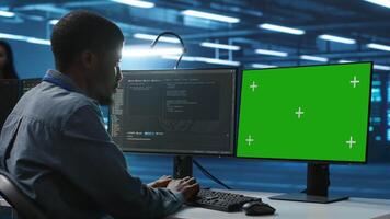 Mitarbeiter Arbeiten auf Grün Bildschirm Computer im Server Nabe fähig von wird bearbeitet riesig Beträge von Daten. es Entwickler beim Tippen beim Chroma Schlüssel PC, Aktualisierung Server steuern Netzwerk Ressourcen video