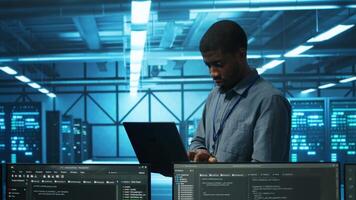 Gerente dentro servidor cubo usando computador portátil para encontrar firewall configurações incorretas afetando montagens em rack desempenho. Supervisor verificação sistemas gargalos conduzindo para lerdo dados transferir cotações video