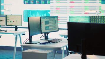 Empty telecommunications company system control and monitoring room, coworking space equipped with a big screen to follow and monitor enterprise statistics or progress. Camera A. video