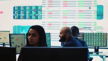 Company employees employing big data used in solving tasks, studying infographics on a huge display. Business analysts reviewing current situation numbers for annual reports. Camera A. video