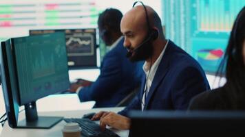 Team of forecast affiliates examining annual infographics on a big data screen, using workflow statistics at workstations. Diverse corporation employees reviewing latest budgeting plans. Camera A. video