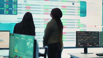 Enterprise colleagues reviewing efficiency and performance metrics within the organization, giving project insight. Partners evaluating statistics and data reports on a big screen. Camera A. video