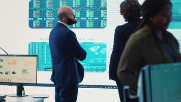 General manager and CEO sharing insight about a new development strategy with data on a big screen, presenting annual infographics to analyze business activity status. Investors team. Camera A. video