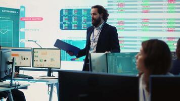 lagkamrater och chef montering i en stor data rum till gå över deras resultat, granskning grafisk representationer med respons från aktieägare investerare. utbyte perspektiv. kamera a. video