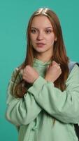 Vertical Assertive woman shows letter X with arms crossed, staying in warrior stance, showing fierceness. Firm young person using negative body language to signal rejection, studio background, camera A video