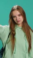 Vertical Frustrated woman showing thumbs down sign gesturing, disapproving and offering negative feedback. Disappointed girl doing dislike hand gesture, studio background, camera A video