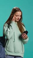 Vertical Young girl suffering from illness upset about needing to take medicine, holding pill bottle. Ill woman preparing to take need dose of vitamin supplements, studio background, camera B video