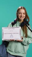 Vertical Happy student holding diploma talking in microphone, addressing audience, holding speech, studio background. Inspiring teenager using mic to share feeling during graduation ceremony, camera B video