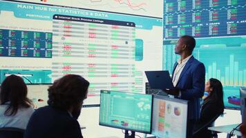 Chief financial officer studying capital funds and revenue data on big screen, verifying annual reports and budget allocation for a project. Looking for ways to increase profit. Camera B. video