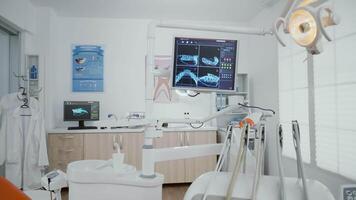 interiör av tömma stomatologi ortodontist kontor rum utrustad med x stråle på monitorer medicinsk dental verktyg beredd för tandvård kirurgi. arbetsplats skåp för hygien tänder, behandling klinik video