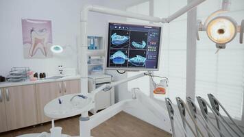 esvaziar estomatologia ortodôntico escritório quarto equipado com profissional odontologia Ferramentas pronto para médico dentes cirurgia. dente raio X imagens em monitor revelar cuidados com os dentes diagnóstico. Largo para ampliação Fora dentro tiro video