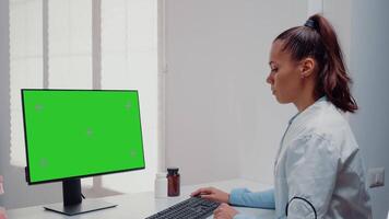 Dentist working with horizontal green screen on computer for teethcare at dental office. Woman using keyboard and monitor with chroma key for mockup template and isolated background video