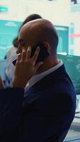 verticaal bedrijf analist doet een presentatie met project updates Aan telefoon telefoongesprek, bespreken met Directeur naar ervoor zorgen organisatorisch succes. werknemer toewijzen middelen volgens naar de markt behoeften. camera b. video