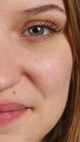 Vertical Extreme close up shot of cheerful joyous girl smiling, isolated over blue studio background. Portrait of happy upbeat teenager grinning, having positive facial expression video