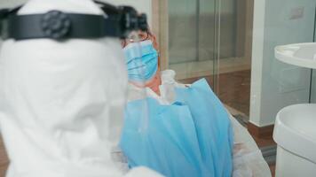 personnes âgées patient avec masque écoute dentiste Conseil examiner dans stomatologique clinique pendant coronavirus pandémie. médecin parlant avec femme portant protection costume, combinaison, visage bouclier et gants video