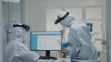 Orthodontic assistant working on computer at oral cabinet while professional dentist consulting patient with dental equipment. Nurse using technology and screen monitor during pandemic video