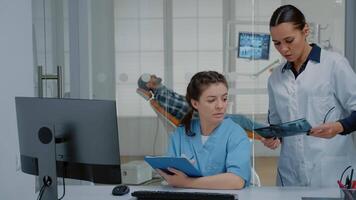 Professional team of dentist and nurse working on patient teethcare using dental x ray scan, stomatology equipment and computer at dentistry clinic. Orthodontists with medical tools video