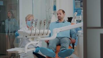 estomatologista fazendo dental exame com ortodôntico Ferramentas e instrumentos, tratando paciente com dor de dente. dentista usando broca e odontologia equipamento às oral Cuidado exame. video