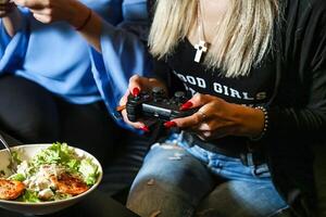 Woman Holding Game Controller and Bowl of Food photo