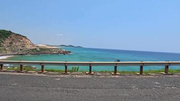 conducción en un la carretera por el mar con claro agua, amarillo arena, rocas phu yen video