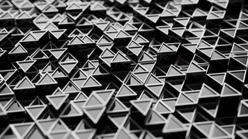 Looping animation of a group of black plastic triangular geometric shapes. video