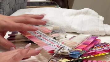 Professional nail salon. Close-up of hands selecting a nail polish color from a sample wheel, showcasing various shades. video