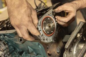 Mechanic's Hands Restoring Vintage Engine photo