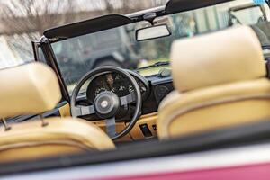 Vicenza Italy 19 March 2024 Close up photo featuring the vintage charm of an Alfa Romeo Duetto s steering wheel and dashboard