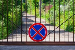 firmar estacionamiento es prohibido en el metal portón en un antecedentes de el parque foto